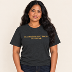 Frau trägt das T-Shirt „Leadership Isn’t Loud. It’s Clear.“ in Dark Heather Grey